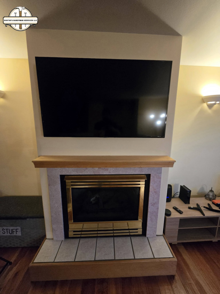 A flat-screen TV professionally mounted above a fireplace by Dustin's Handyman Services LLC in Great Falls, MT.