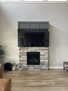 TV mounted above a stone fireplace with custom decorative paneling installed by IGM Handyman Services in Meridian, ID.