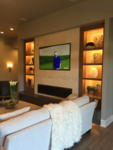 Living room with mounted TV, built-in shelves, and accent lighting installed by T. Wheeler Homes, LLC in Salem, OR