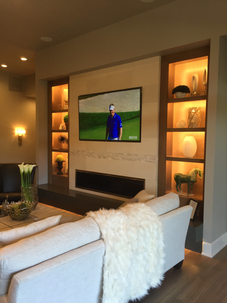 Living room with mounted TV, built-in shelves, and accent lighting installed by T. Wheeler Homes, LLC in Salem, OR