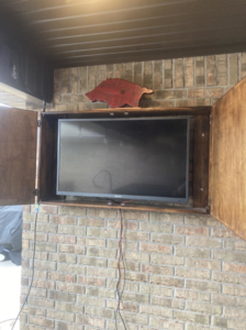 A television mounted inside a custom-built wooden cabinet by HandyMan of NWA in Rogers, AR