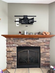 A heavy-duty TV wall mount installed above a fireplace by Med City Handy Ma'am in Rochester, MN