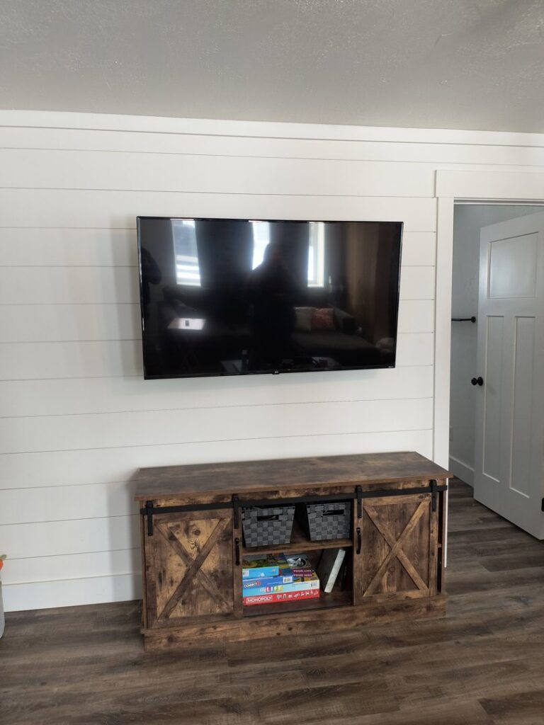 A flat-screen television professionally mounted on a wall above a console by T&K Services in Idaho Falls, ID