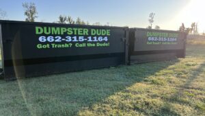 Two branded black dumpsters from Dumpster Dude, ready for junk removal or rental services in Amory, MS.