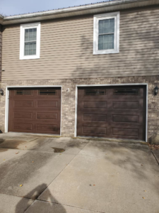 Two newly installed brown garage doors on a residential home by Lucas Overhead Doors, a general contractor in Erie, PA
