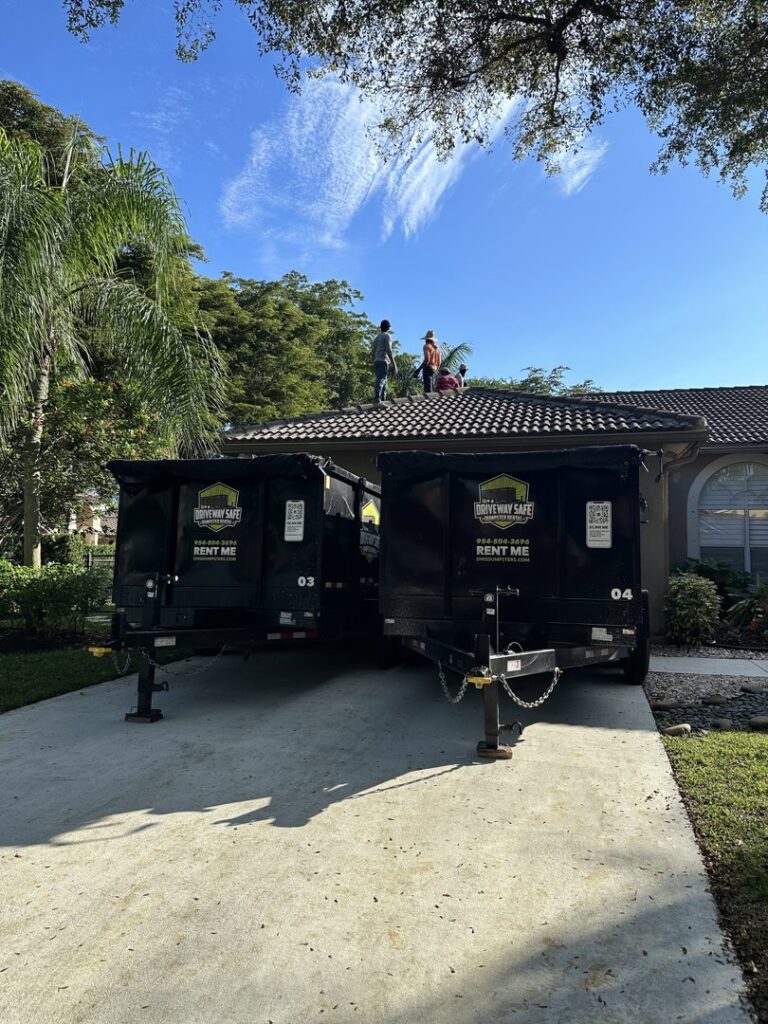 Two Driveway Safe Dumpster Rental trailers on site for a roofing project, ready to collect debris in Fort Lauderdale, FL.