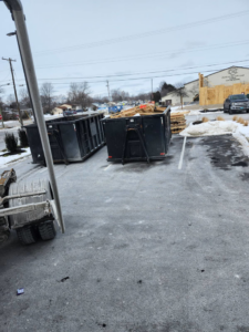 Two large dumpsters, one filled with wood debris, ready for pickup by BigDumpster.com in Cleveland, OH.