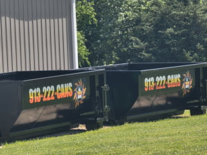 Two black dumpsters from KC TRASH GUYS LLC ready for junk removal services in Johnson county, MO.