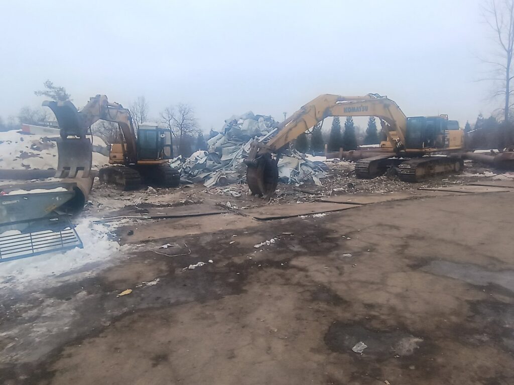 Two excavators processing a large pile of scrap metal and debris at the CycleMET inc. facility in Columbus, OH.