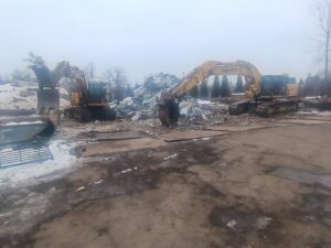 Two excavators processing a large pile of scrap metal and debris at the CycleMET inc. facility in Columbus, OH.