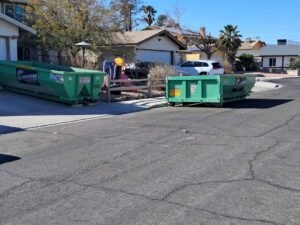 Two green dumpsters from Junk Control placed on a residential street for a large junk removal project in Henderson, NV.
