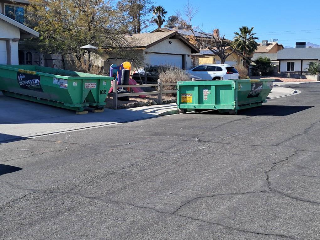 Two green dumpsters from Junk Control placed on a residential street for a large junk removal project in Henderson, NV.