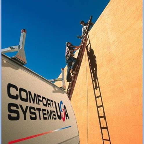 Two handymen from Comfort Systems USA Indiana on ladders performing exterior building repair in Indianapolis, IN.