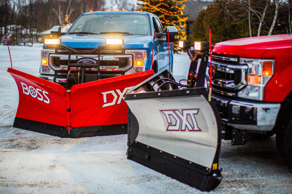 Two heavy-duty pickup trucks outfitted with snow plows, showcasing services from Handyman Vehicle Outfitters in Portland, ME.