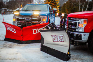 Two heavy-duty pickup trucks outfitted with snow plows, showcasing services from Handyman Vehicle Outfitters in Portland, ME.