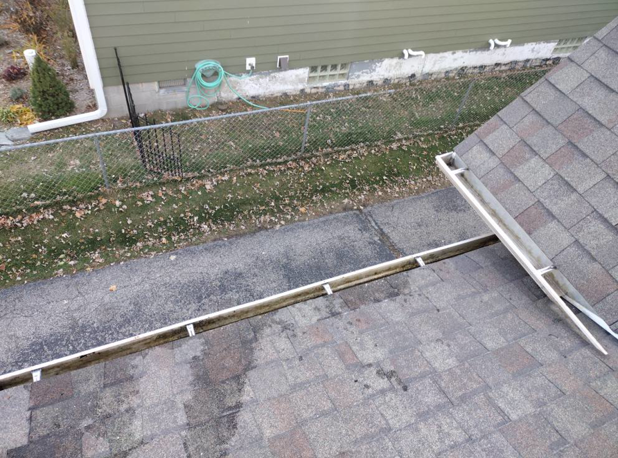 Two sections of dirty gutters on a house roof, indicating the need for professional cleaning services from Schu Can Do 2-Property Services LLC in Warren, MI.