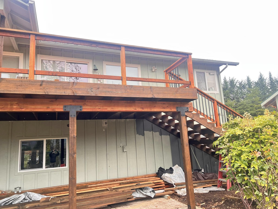 A two-story deck construction project with lumber and painting visible by One Up construction llc in Springfield, OR.