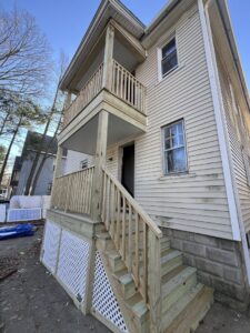 A newly constructed two-story wooden deck and stairs by TD Estimating Group LLC in Springfield, MA, for outdoor living.