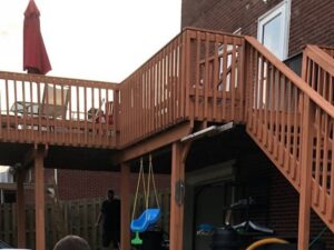 A multi-level wooden deck with stairs leading to a lower patio area, built by McIntyre's Renovations LLC in Pittsburgh, PA