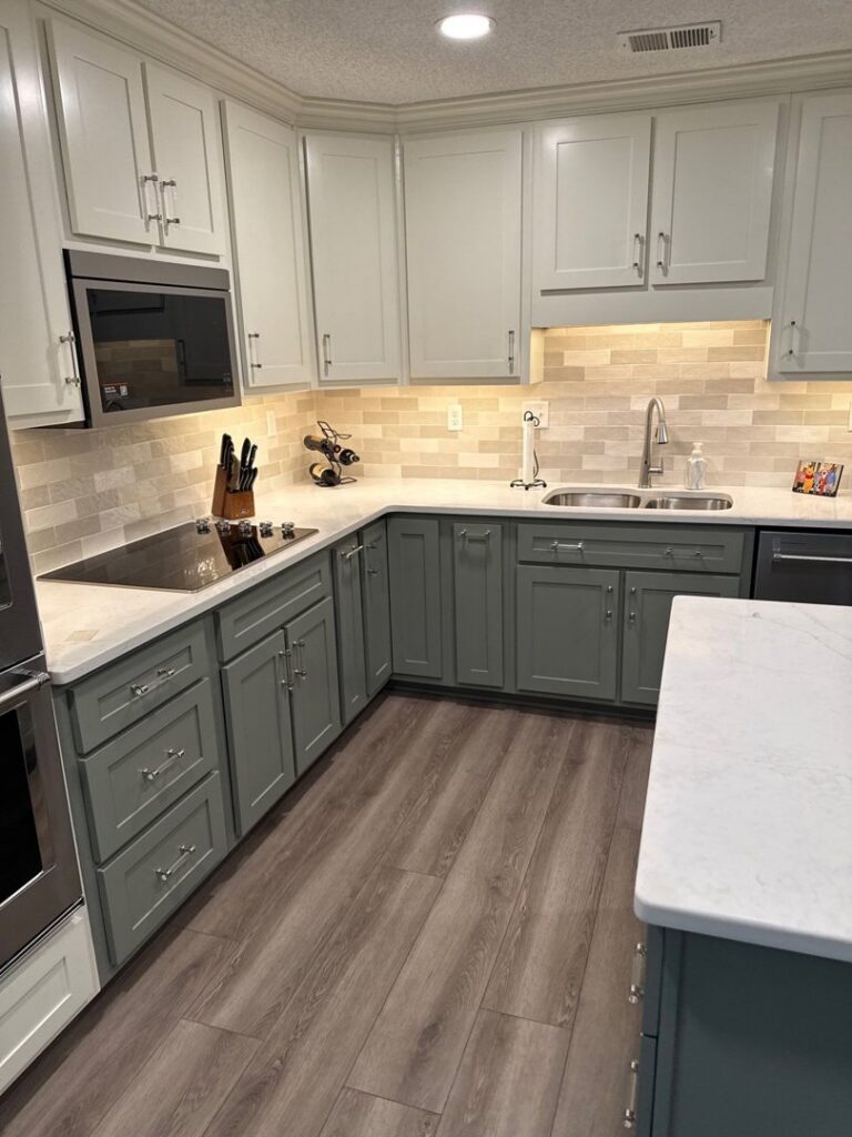 A modern kitchen remodel with two-tone cabinets, white countertops, and subway tile backsplash by CMT Construction LLC in Columbia, MO.