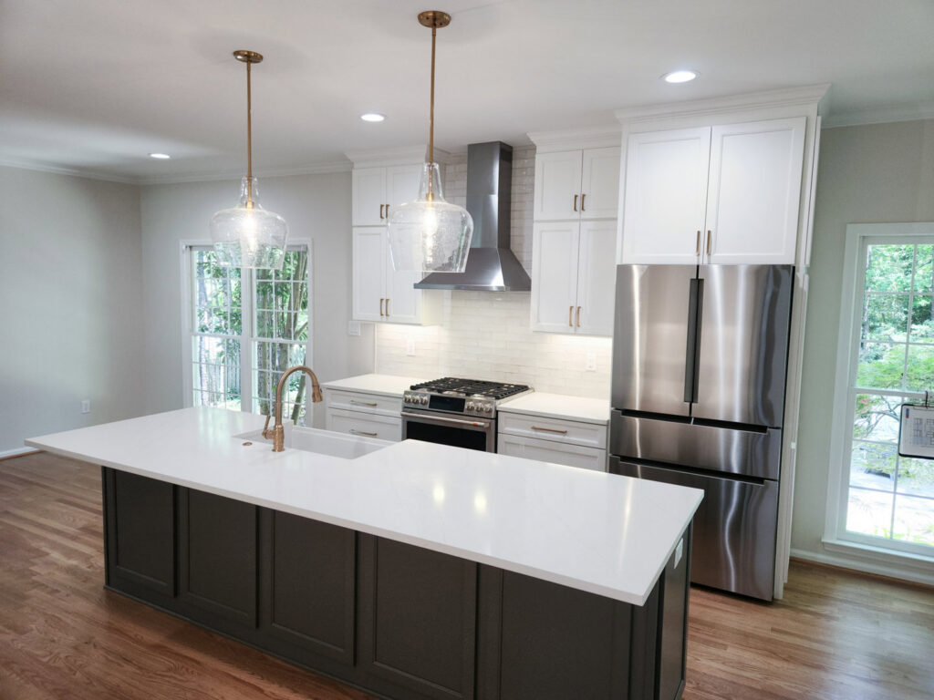A modern kitchen with two-tone cabinets, a large island, and new appliances by Berco Construction LLC in Godfrey, IL