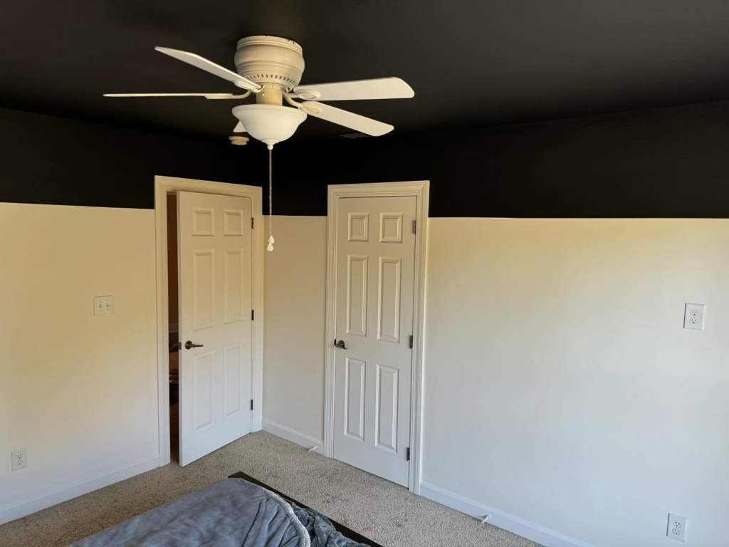 A room with a stylish two-tone wall paint job and a newly installed ceiling fan by Wilder Painting, LLC in Quincy, MA