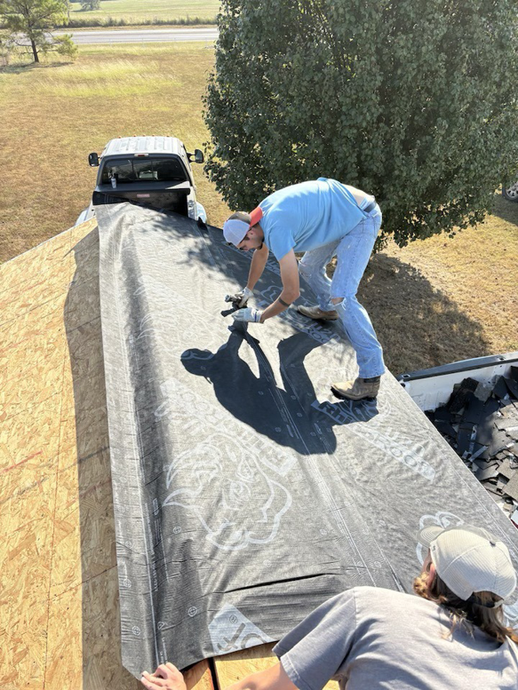 Two workers installing roofing underlayment for Hansen Construction Stillwater in Stillwater, OK.
