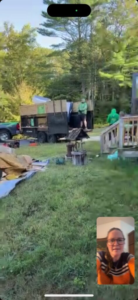 Two workers actively loading various items and debris into the back of a junk removal truck for Trash King LLC in Peoria, AZ.