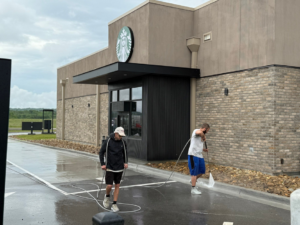 Two workers pressure washing the exterior and drive-thru area of a Starbucks building for Selk Solutions in Crossville, TN.