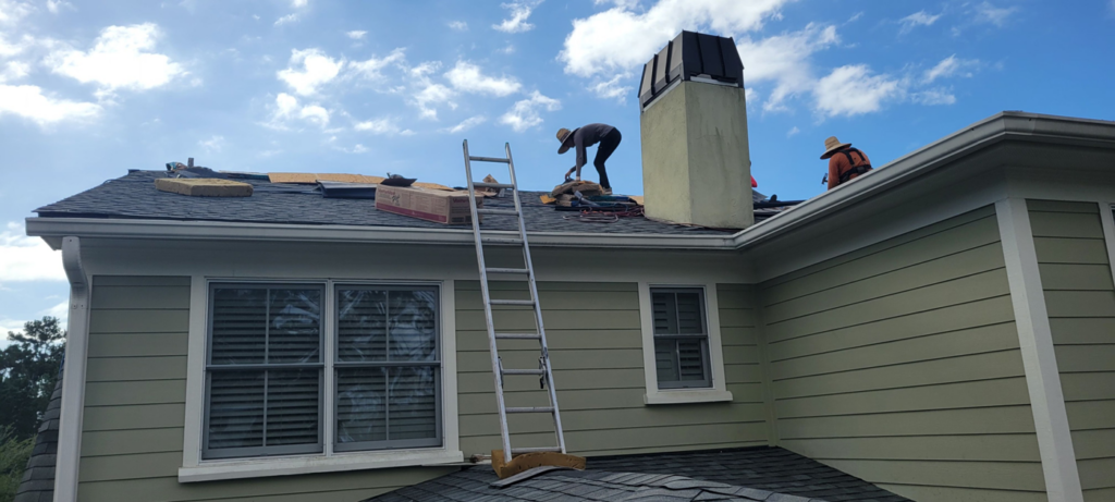 Two workers performing a roofing project with a ladder for WITTE CONSTRUCTION LLC in Mount Pleasant, SC.