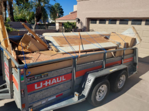 A U-Haul trailer fully loaded with construction debris and wood, ready for transport by Arizona Junk Removal LLC in Phoenix, AZ
