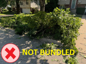 A large pile of unbundled tree branches and leaves on the curb, awaiting junk removal by D&D Refuse Inc. in Lincoln, NE.