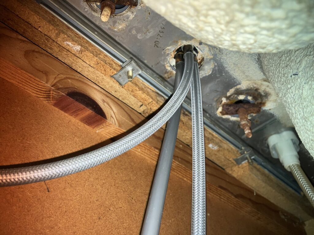 Close-up view of under-sink plumbing connections and water lines, a service provided by Better Than Your Last Handyman in St. Charles, MO.