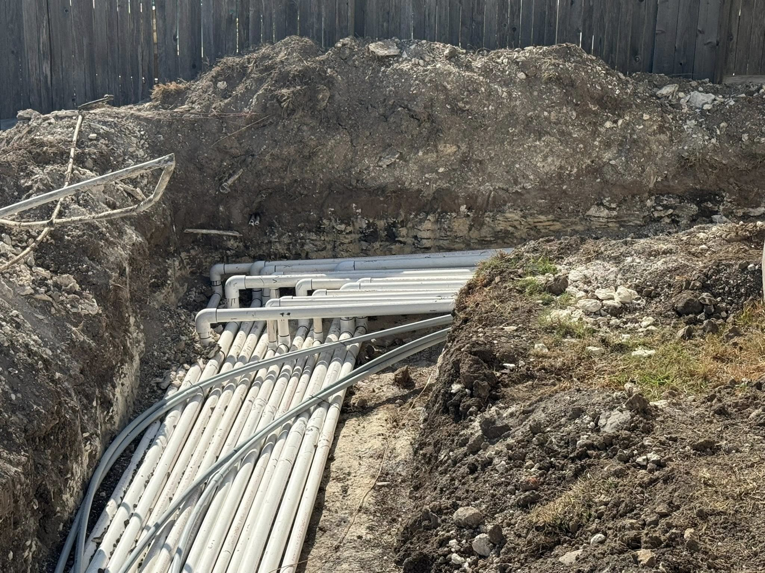 Underground pipe installation in a trench, showing multiple conduits, by Stealth Civil Contracting in Austin, TX.