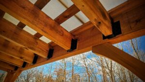 Close-up view of the underside of a pergola roof, showing wooden beams and metal brackets by Minnesota Pergolas in Lakeland, MN.