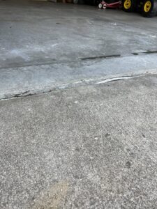 A section of an uneven concrete driveway slab, showing a tripping hazard that A1 Concrete Leveling Cincinnati/NKY can fix in Cincinnati, OH.