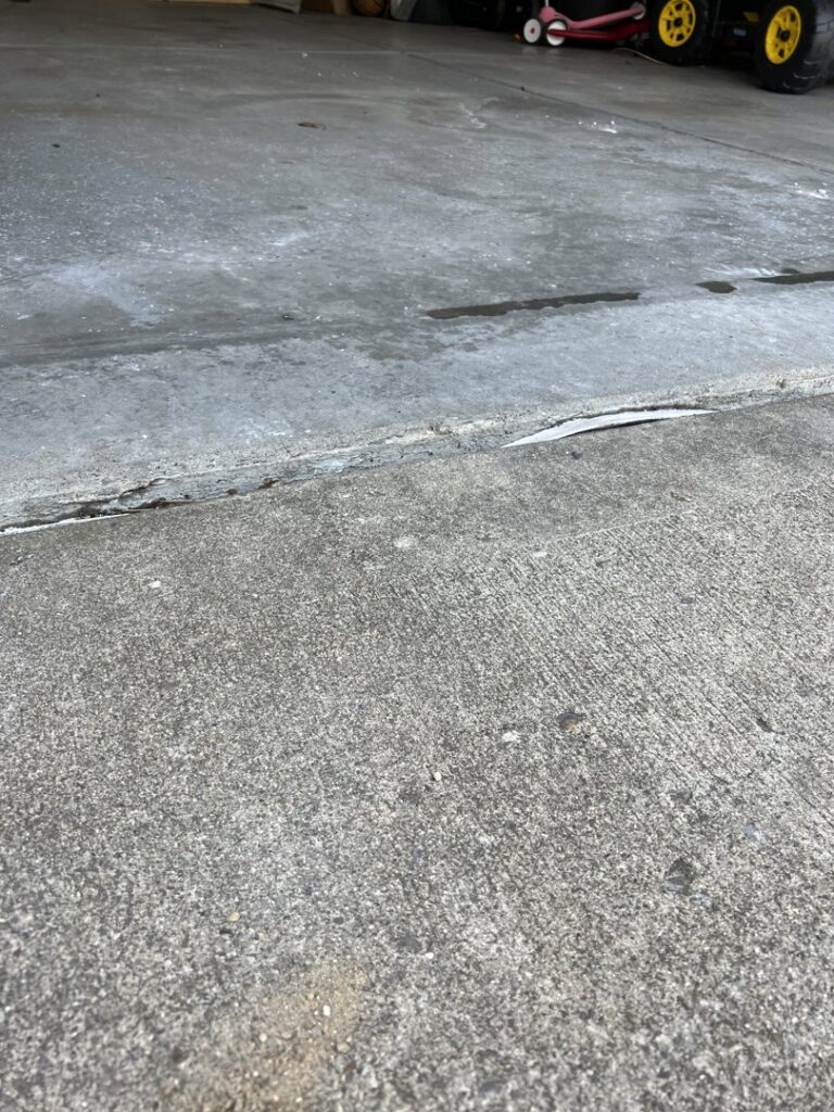 A section of an uneven concrete driveway slab, showing a tripping hazard that A1 Concrete Leveling Cincinnati/NKY can fix in Cincinnati, OH.