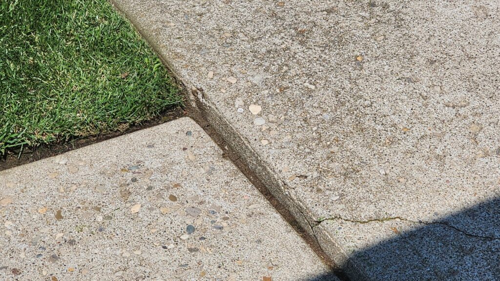 A close-up view of uneven and cracked concrete slabs on a walkway, a common issue fixed by A1 Concrete Leveling Cincinnati/NKY in Cincinnati, OH.