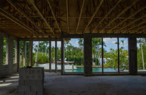 An unfinished interior of a waterfront home under construction, showing exposed joists and concrete blocks by Intelligent Construction Inc. in Miami, FL.