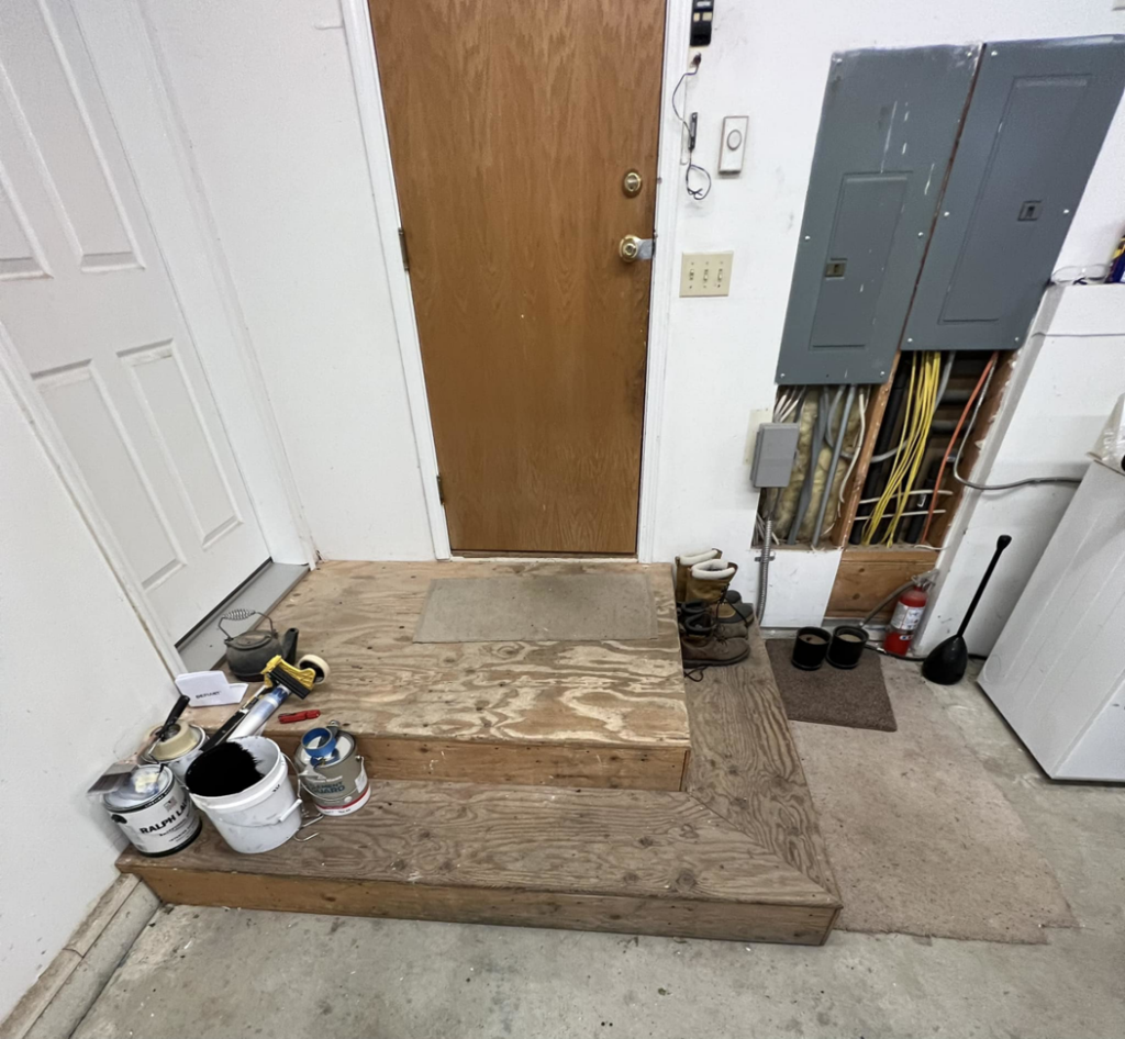 Unfinished wooden steps and platform in a garage before painting by JKM Services in Solon, OH.