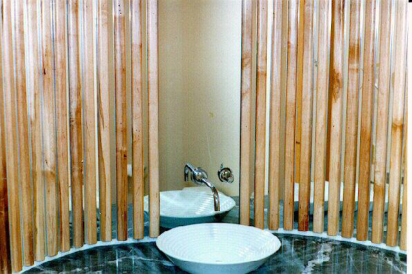 A unique bathroom design with a wooden slat partition and modern vessel sinks by Cohaco Building Specialties in Peoria, AZ.
