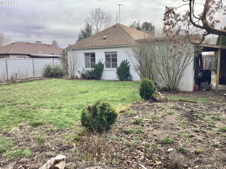 An unkempt and overgrown backyard needing cleanup and landscaping services from Gordon Homes LLC in Portland, OR.