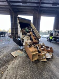 A dump trailer unloading a variety of household junk and debris at a disposal facility by Tidy Loaders Junk Removal in Houston, TX.