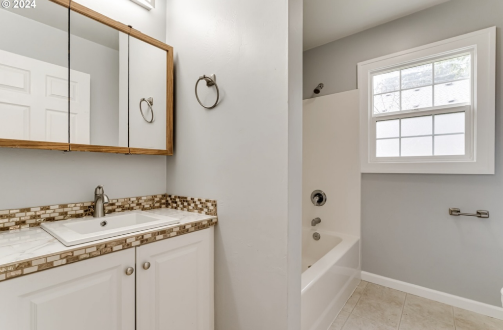 An updated bathroom with a new vanity, sink, and bathtub by Green Peaks Painting and Remodeling in Elmira, OR
