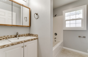 An updated bathroom with a new vanity, sink, and bathtub by Green Peaks Painting and Remodeling in Elmira, OR