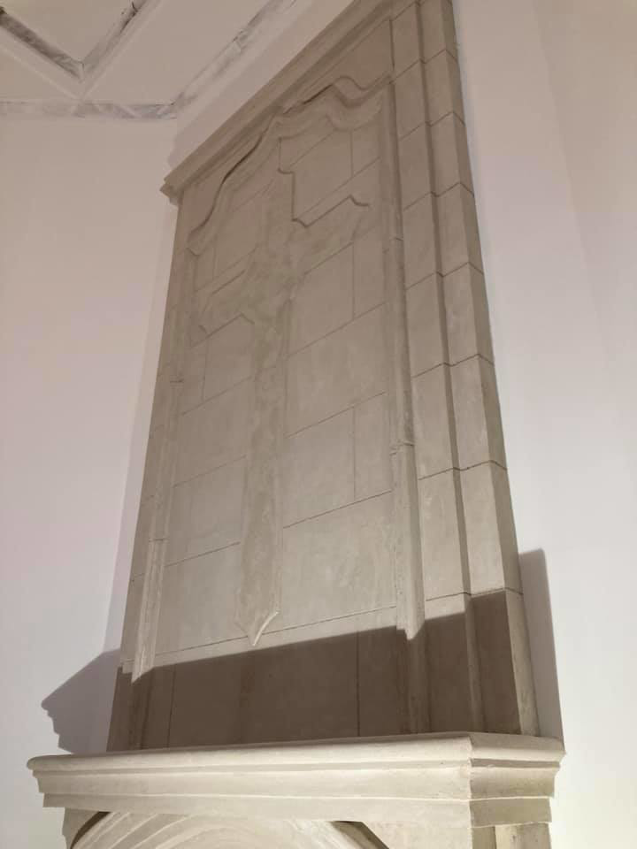 Upper section of a custom masonry fireplace featuring a detailed cross design by Old Style European Stucco & Masonry in Brentwood, TN