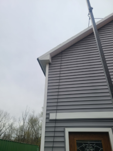Upper siding installation with a material lift on a building by Jos Construction LLC in Trenton, NJ.