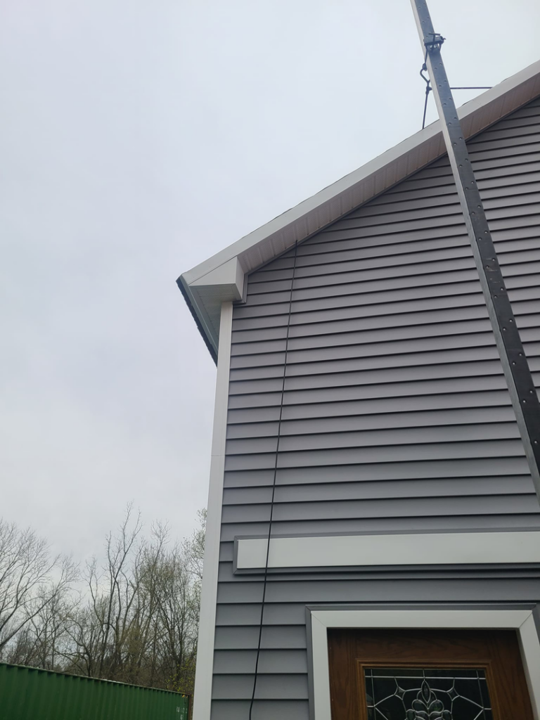 Upper siding installation with a material lift on a building by Jos Construction LLC in Trenton, NJ.