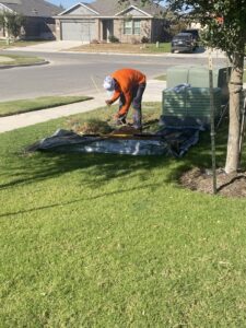 A worker performing utility line installation or repair near a green utility box for RamTelecomLLC in Houston, TX