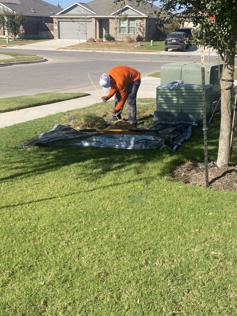 A worker performing utility line installation or repair near a green utility box for RamTelecomLLC in Houston, TX